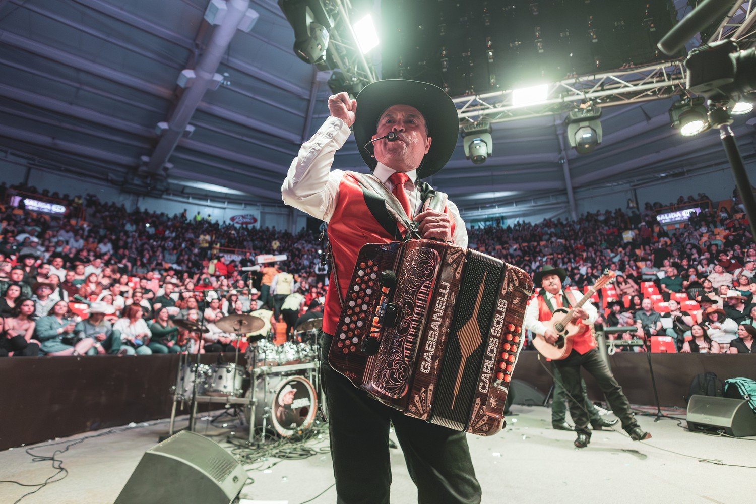 Carlos Solís on accordion during a rodeo arena performance